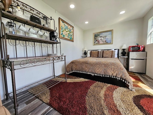 bedroom with freestanding refrigerator, recessed lighting, and wood finished floors