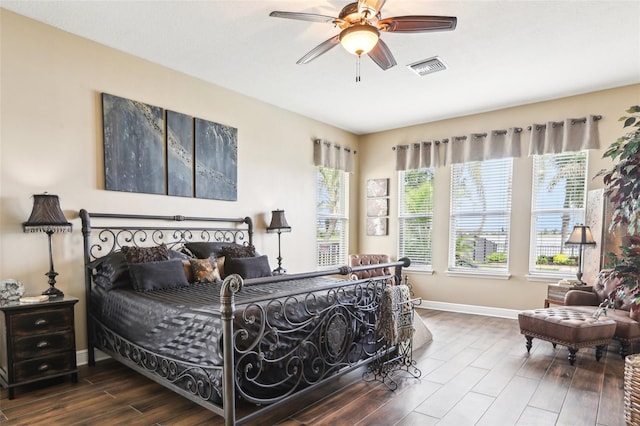bedroom with wood finished floors, multiple windows, baseboards, and a ceiling fan