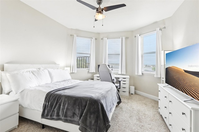 bedroom with light carpet, baseboards, and ceiling fan