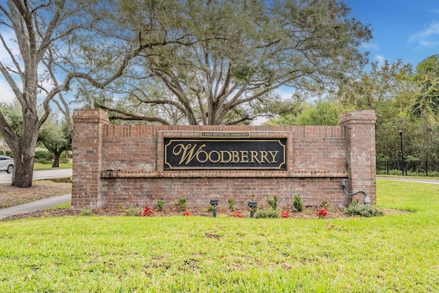 community / neighborhood sign featuring a lawn