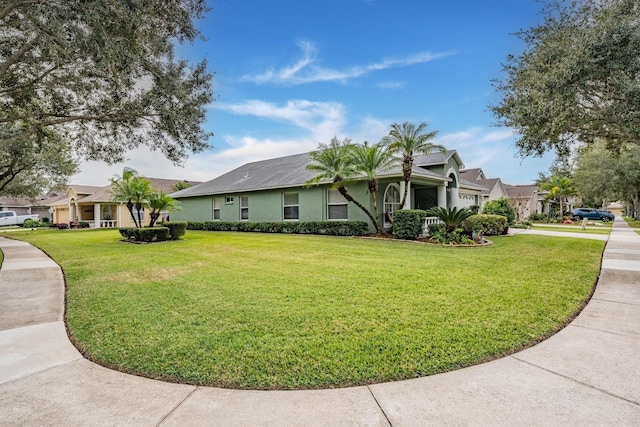 view of side of property with stucco siding, a lawn, and driveway