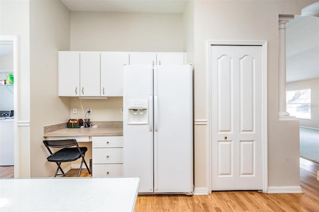kitchen featuring white refrigerator with ice dispenser, light wood-type flooring, white cabinets, and light countertops