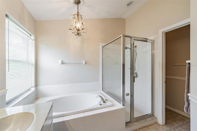 bathroom featuring a shower stall, a garden tub, tile patterned flooring, a chandelier, and a sink