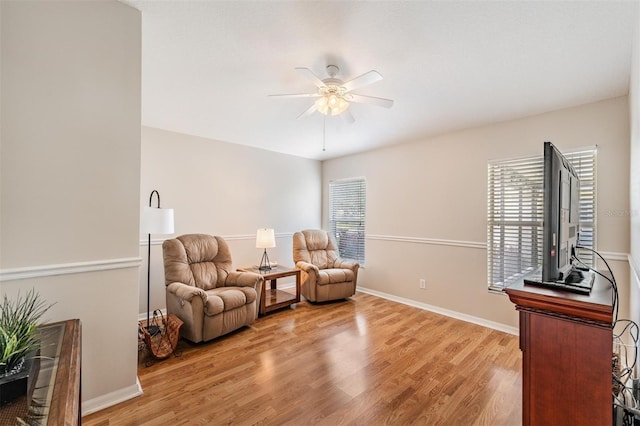 sitting room featuring a ceiling fan, wood finished floors, and baseboards