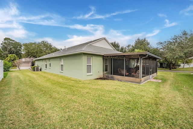 back of house featuring a sunroom, central AC, and a lawn