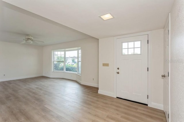foyer with light wood-style floors, baseboards, and ceiling fan