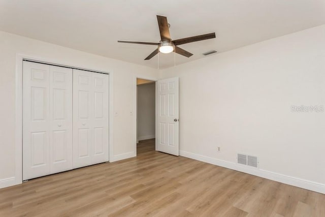 unfurnished bedroom featuring light wood-style floors, baseboards, a closet, and ceiling fan