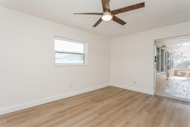 spare room featuring light wood-type flooring, ceiling fan, and baseboards