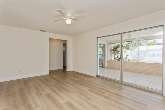 empty room featuring ceiling fan, light wood finished floors, and baseboards
