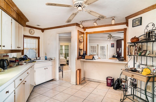 504 Casas Bonitas Dr, Nokomis, FL 34275 - kitchen with ceiling fan, light countertops, crown molding, white cabinets, and light tile patterned flooring