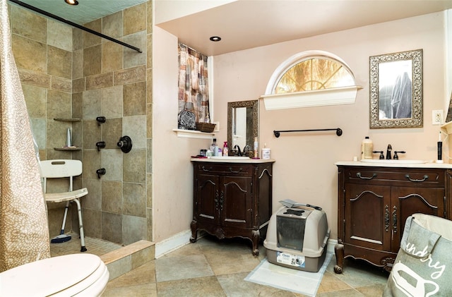 504 Casas Bonitas Dr, Nokomis, FL 34275 - full bathroom with walk in shower, two vanities, baseboards, and toilet