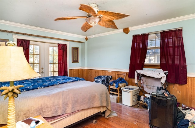 504 Casas Bonitas Dr, Nokomis, FL 34275 - bedroom with french doors, wainscoting, crown molding, wood finished floors, and wooden walls