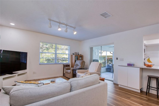 2870 Rampart Cir, Clearwater, FL 33761 - living area featuring wood finished floors, healthy amount of natural light, track lighting, and baseboards