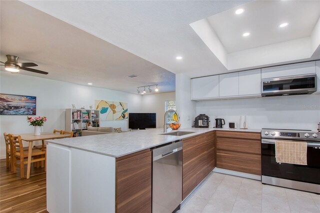 2870 Rampart Cir, Clearwater, FL 33761 - kitchen featuring stainless steel appliances, a sink, modern cabinets, a peninsula, and light countertops