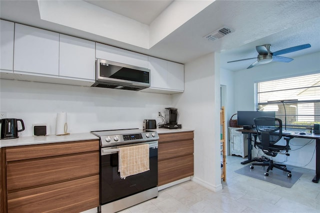 2870 Rampart Cir, Clearwater, FL 33761 - kitchen featuring stainless steel appliances, white cabinets, light countertops, and a desk