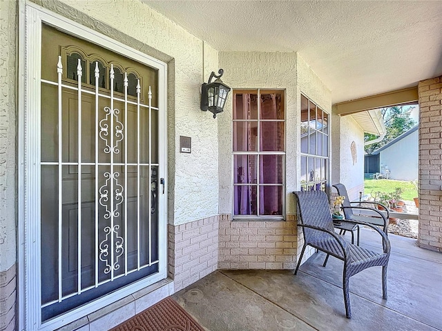 10520 Tapestry Dr, Port Richey, FL 34668 - entrance to property with a porch, stucco siding, and brick siding