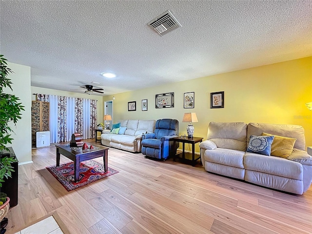 10520 Tapestry Dr, Port Richey, FL 34668 - living area featuring light wood-style floors, a textured ceiling, and a ceiling fan