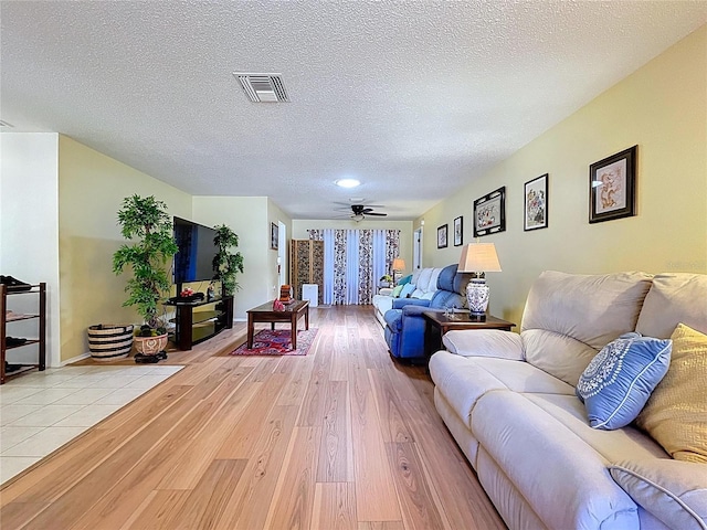 10520 Tapestry Dr, Port Richey, FL 34668 - living room with light wood-type flooring, a textured ceiling, and ceiling fan