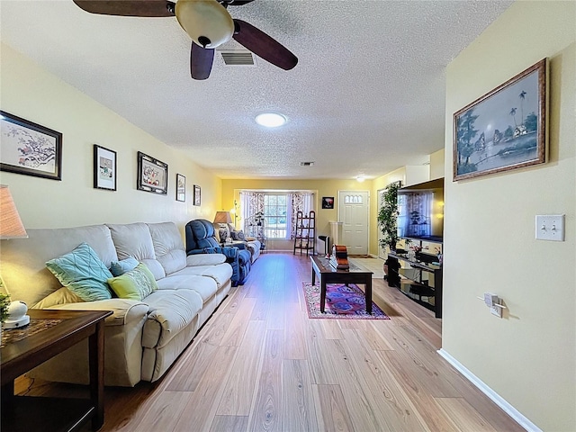 10520 Tapestry Dr, Port Richey, FL 34668 - living area with a textured ceiling, light wood-style floors, and a ceiling fan