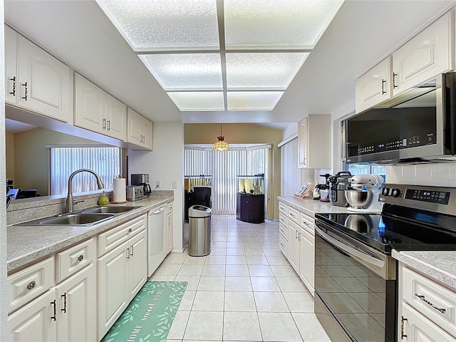 10520 Tapestry Dr, Port Richey, FL 34668 - kitchen featuring appliances with stainless steel finishes, white cabinetry, light countertops, light tile patterned floors, and a textured ceiling