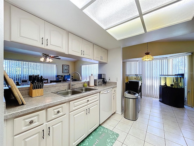 10520 Tapestry Dr, Port Richey, FL 34668 - kitchen featuring dishwasher, light tile patterned floors, white cabinets, light countertops, and plenty of natural light