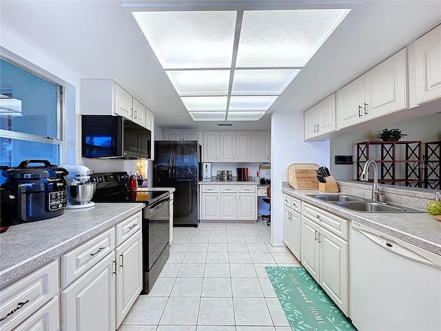 10520 Tapestry Dr, Port Richey, FL 34668 - kitchen with black appliances, light tile patterned flooring, light countertops, and white cabinetry