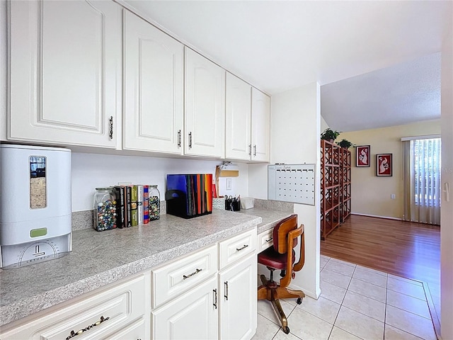 10520 Tapestry Dr, Port Richey, FL 34668 - kitchen with light tile patterned floors, light countertops, and white cabinets