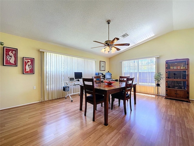 10520 Tapestry Dr, Port Richey, FL 34668 - dining area featuring ceiling fan, light wood-style flooring, a textured ceiling, and lofted ceiling