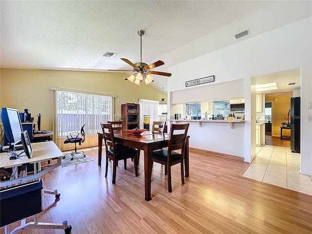 10520 Tapestry Dr, Port Richey, FL 34668 - dining room with a ceiling fan, light wood finished floors, a textured ceiling, an office area, and high vaulted ceiling