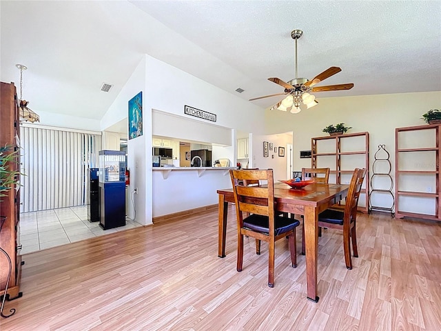 10520 Tapestry Dr, Port Richey, FL 34668 - dining area with light wood-type flooring, a ceiling fan, and high vaulted ceiling