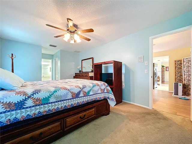 10520 Tapestry Dr, Port Richey, FL 34668 - bedroom with stainless steel fridge, light carpet, ceiling fan, and a textured ceiling