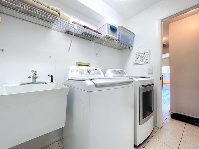 10520 Tapestry Dr, Port Richey, FL 34668 - washroom with washer and dryer and light tile patterned floors