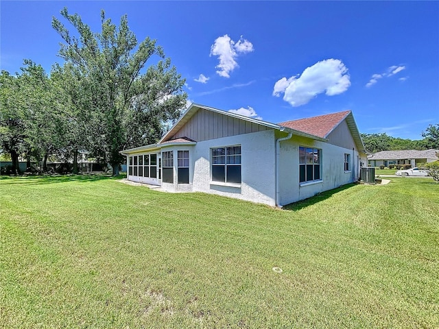 10520 Tapestry Dr, Port Richey, FL 34668 - back of property featuring a lawn, stucco siding, and a sunroom