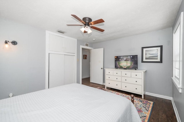 bedroom with wood finished floors, baseboards, a closet, and ceiling fan