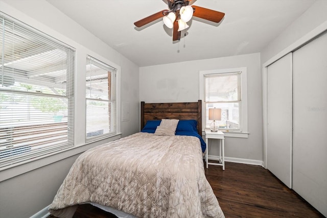 bedroom with wood finished floors, a closet, baseboards, and ceiling fan