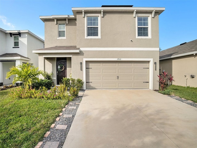 17012 Oval Rum Dr, Wimauma, FL 33598 - view of front facade featuring stucco siding, driveway, a garage, and a front lawn