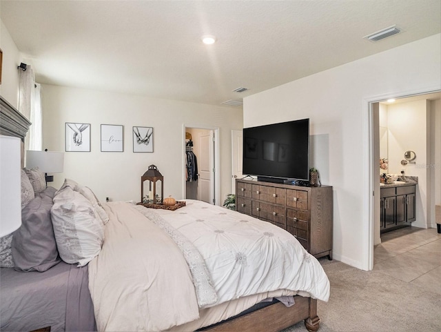 17012 Oval Rum Dr, Wimauma, FL 33598 - bedroom featuring a walk in closet, light colored carpet, ensuite bathroom, and a closet