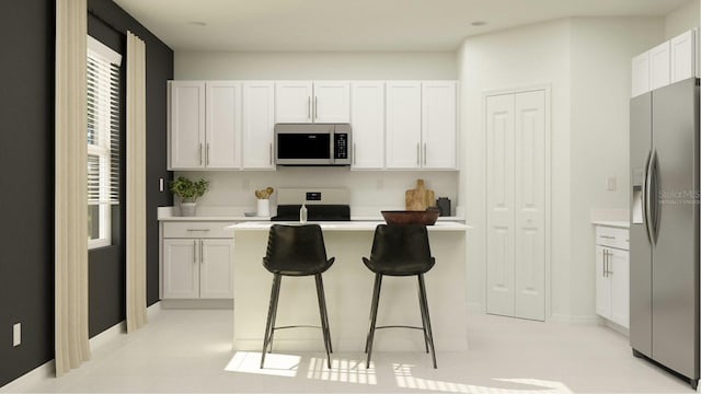 2203 Chris Dr, Winter Haven, FL 33884 - kitchen with appliances with stainless steel finishes, a breakfast bar area, white cabinetry, light countertops, and a kitchen island