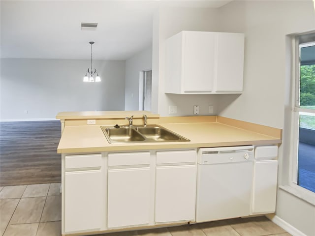 kitchen with white dishwasher, a sink, light countertops, white cabinets, and a peninsula