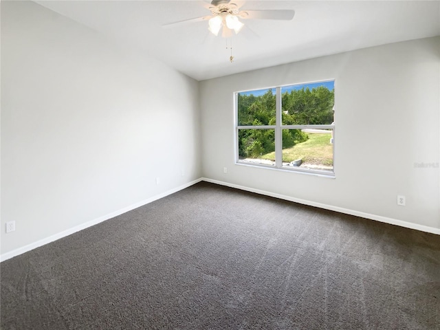 unfurnished room with dark carpet, a ceiling fan, and baseboards