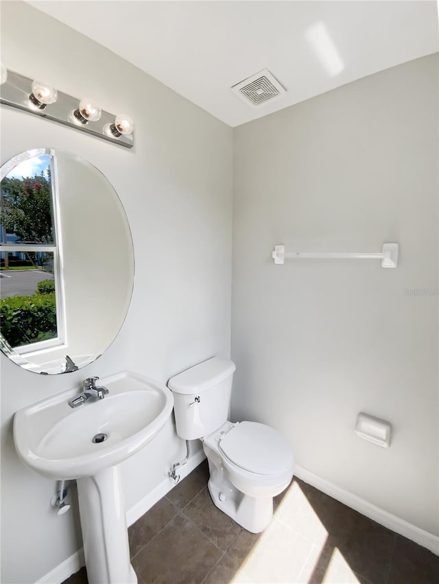 bathroom featuring toilet, tile patterned flooring, and baseboards