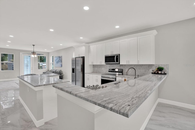 4071 45th Ave N, Saint Petersburg, FL 33714 - kitchen featuring appliances with stainless steel finishes, light marble finish flooring, decorative backsplash, a sink, and recessed lighting