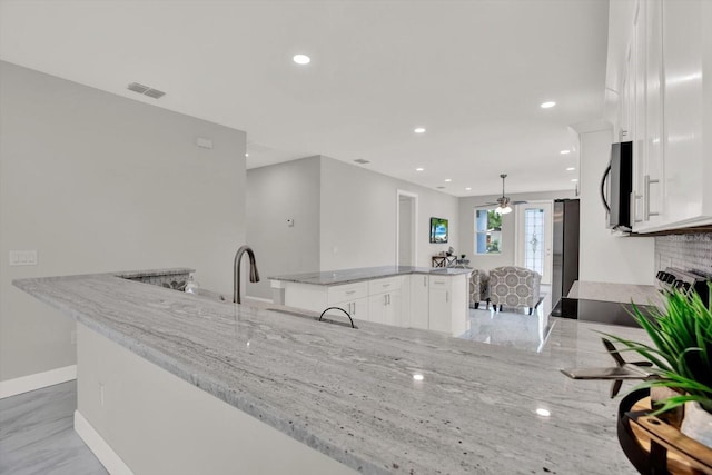 4071 45th Ave N, Saint Petersburg, FL 33714 - kitchen with a center island, white cabinets, stainless steel appliances, baseboards, and ceiling fan