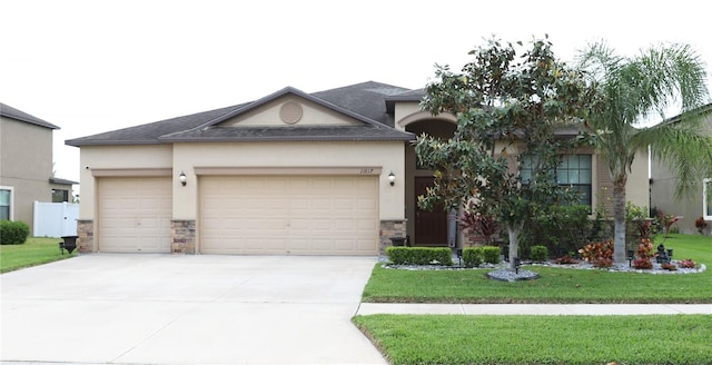 11617 Brighton Knoll Loop, Riverview, FL 33579 - view of front of property with stone siding, stucco siding, an attached garage, and driveway