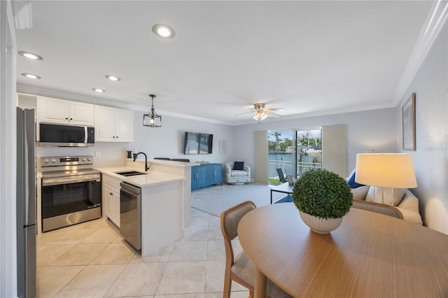 4103 Gulf Blvd Unit 107, St Pete Beach, FL 33706 - kitchen with stainless steel appliances, a peninsula, a sink, crown molding, and open floor plan