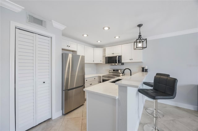 4103 Gulf Blvd Unit 107, St Pete Beach, FL 33706 - kitchen with stainless steel appliances, a peninsula, white cabinetry, light tile patterned flooring, and recessed lighting