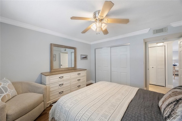 4103 Gulf Blvd Unit 107, St Pete Beach, FL 33706 - bedroom featuring crown molding, a ceiling fan, a closet, light wood-type flooring, and baseboards