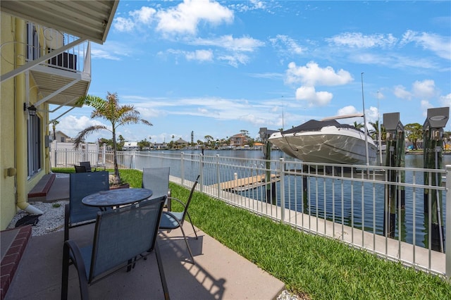 4103 Gulf Blvd Unit 107, St Pete Beach, FL 33706 - view of patio featuring boat lift, a water view, a dock, and outdoor dining area