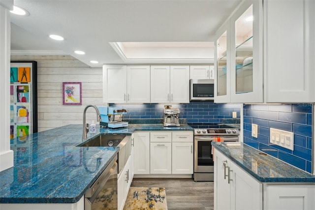 7564 Bayshore Dr Unit 302, Treasure Island, FL 33706 - kitchen with appliances with stainless steel finishes, a sink, light wood-style floors, white cabinets, and recessed lighting