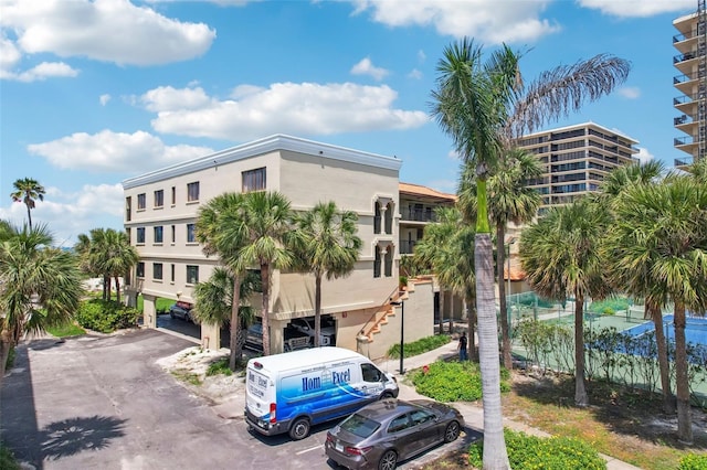 7564 Bayshore Dr Unit 302, Treasure Island, FL 33706 - view of building exterior with uncovered parking and stairway